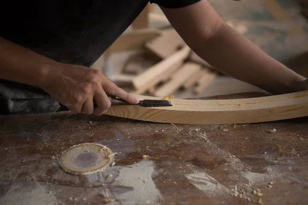 Bir marangoz odun parçasında keski kullanıyor.