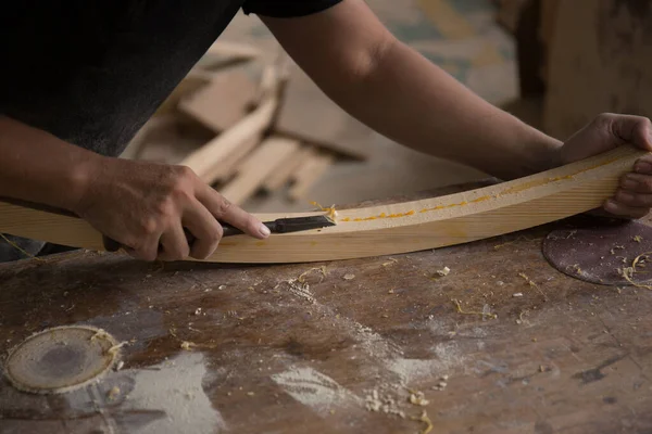 Bir marangoz odun parçasında keski kullanıyor.