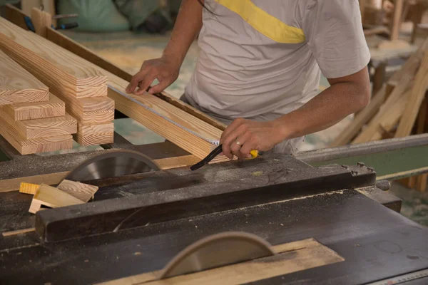 Testereyle odun kesen genç bir işçi.