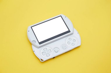 Sarı üzerine izole edilmiş joystick ile beyaz el bilgisayarı oyun konsolunun üst görünümü 