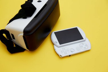 Sarı üzerinde izole edilmiş VR cam ve el bilgisayarı oyun konsolunun üst görünümü 