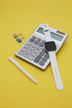 Çizim defterinin üst görüntüsü, kalem ve hesap makinesi sarıda izole edilmiş. Finans kavramı 