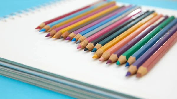 Crayons Crayon Colorés Sur Carnet Sur Fond Bleu — Photo