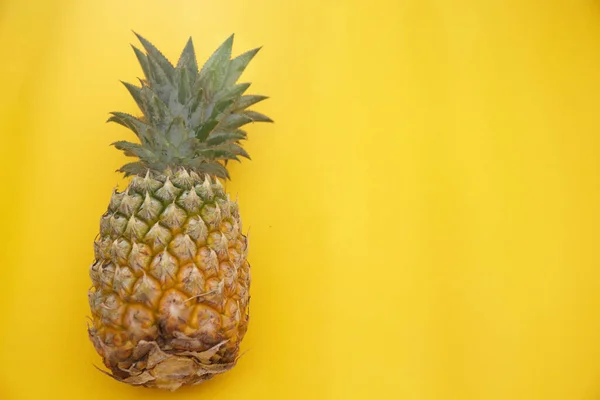 Sarı arkaplanda izole edilmiş ananasın üst görünümü