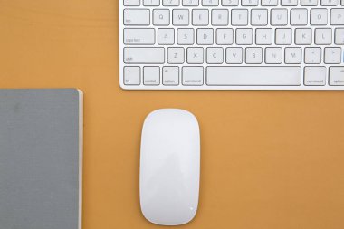 Akıllı telefonun üst görüntüsü, kablosuz klavye, masadaki kalem ve defter. İş konsepti