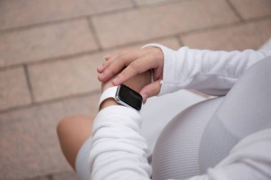 Dışarıda akıllı saat kullanan Asyalı Hamile Kadın