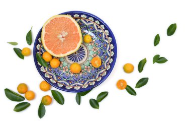 Greyfurt ve citrons plaka dağınık yaprakları ile beyaz bir arka plan üzerinde boyalı eski vintage kesti