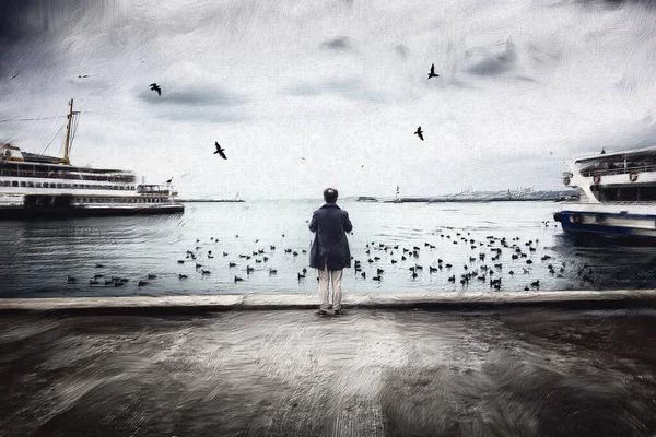 Deniz kenarındaki martıları besleyen birinin görüntüsü.