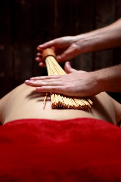 Närbild på ung kvinna får massage med varma stenar — Stockfoto