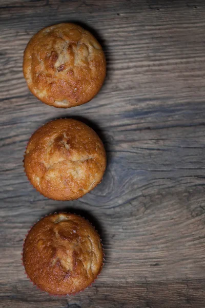 Delicious homemade muffins over wooden board selective focus — Stock Photo, Image