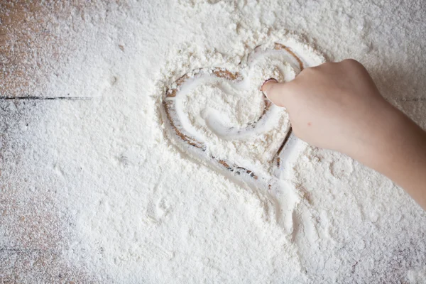 Heart of flour on wooden desk painted by a child — Stock Photo, Image