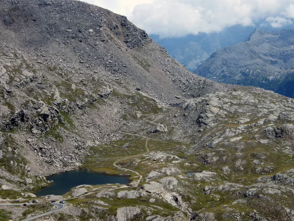 Nivolet 'in geçmesinden hemen önce küçük bir alp gölü yoksul çayırlar ve taşlarla çevrili.