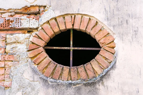 Güneşli bir şubat gününde Guardistallo kasabasındaki tarihi bir evin dış duvarındaki oval pencere.