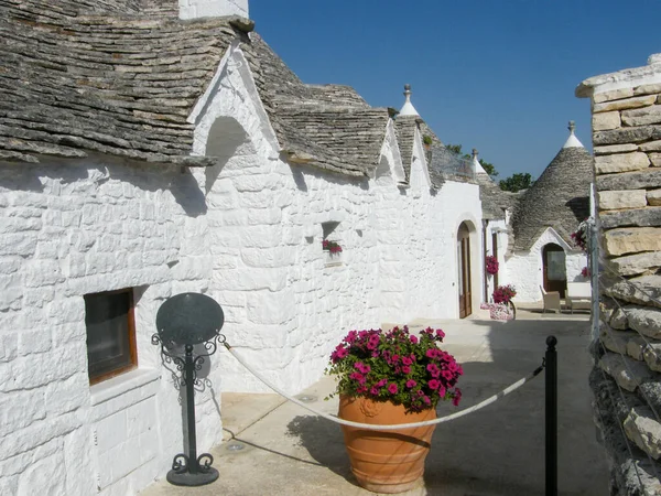 Güneşli bir yaz gününde Alberobello 'da tipik beyaz trulli caddesi