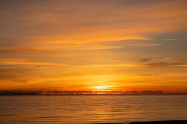Günbatımı için portakal boyalı bir gökyüzü. Arka planda Elba adası profili var. Bir Şubat akşamı.