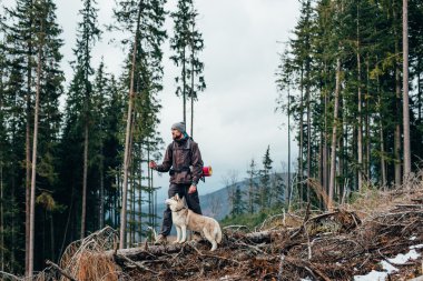 uzun yürüyüşe çıkan kimse ile dağlarda güzel manzaraya bakarak Sibirya husky köpek