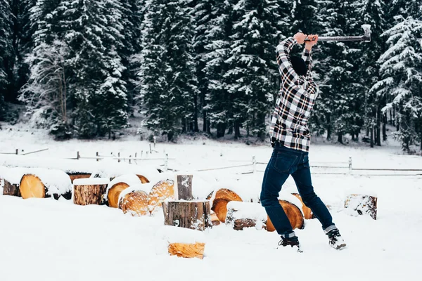 Человек рубит дрова в горах — стоковое фото