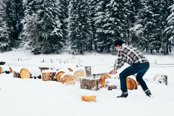 Человек рубит дрова в горах — стоковое фото