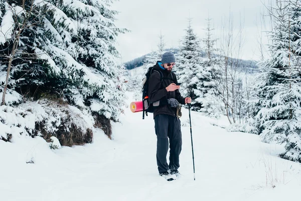 Wanderer mit Handy in verschneiten Bergen — Stockfoto