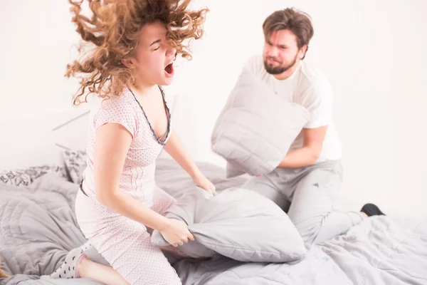 Pillow fighting couple — стоковое фото