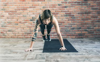 Dövmeli kadın yapıyor kapalı, sportif kadın pratik yoga egzersizleri