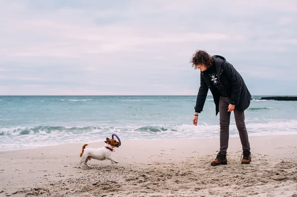 Człowiek z jack russel Terier na plaży — Zdjęcie stockowe