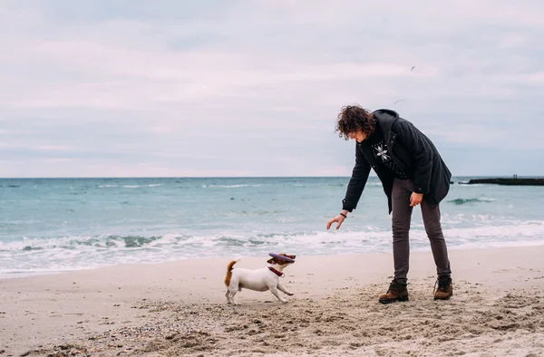 Człowiek z psem na plażę — Zdjęcie stockowe
