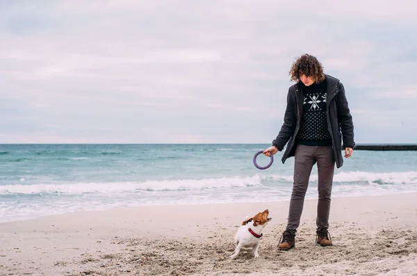 Homem brincando com Jack Russel terrier na praia — Fotografia de Stock