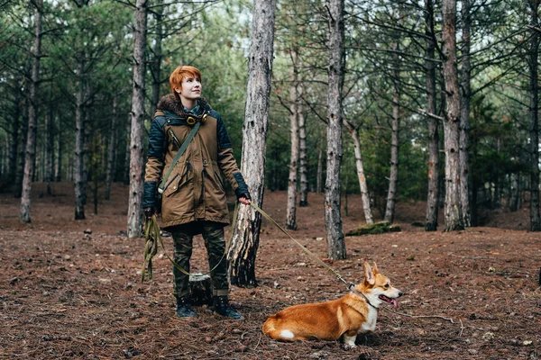 森の中のコーギー犬を連れて歩いて赤毛の女の子 — ストック写真