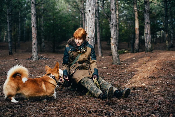 Pelirroja chica caminando con galés corgi perro en el bosque — Foto de Stock