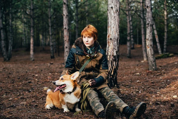 Rödhårig tjej med Walesiska corgi hund i skogen — Stockfoto