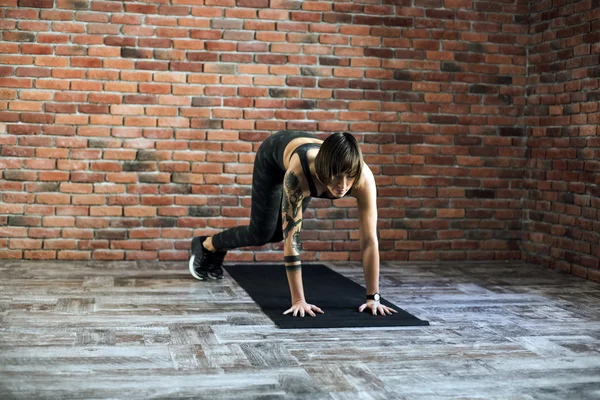 Τατουάζ γυναικείο κάνει ασκήσεις σε εσωτερικούς χώρους, σπορ γυναίκα την πρακτική της γιόγκα — Φωτογραφία Αρχείου
