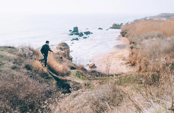 Uomo che gioca con il cane labrador sulla spiaggia — Foto Stock