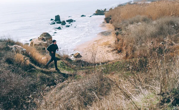 Uomo che gioca con il cane labrador sulla spiaggia — Foto Stock