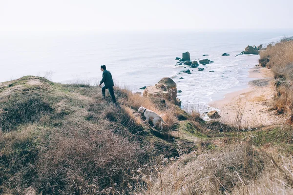 Uomo che gioca con il cane labrador sulla spiaggia — Foto Stock