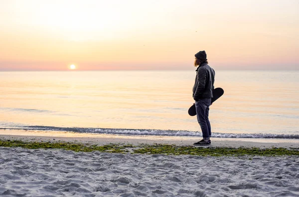 Uomo con pattino sulla spiaggia durante il tramonto all'alba — Foto Stock