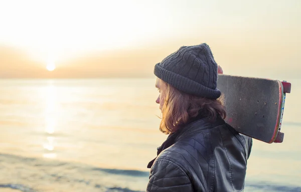 Hombre con patín en la playa al atardecer al amanecer —  Fotos de Stock