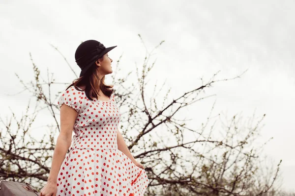 Mujer en ropa vintage con maleta en el campo . — Foto de Stock