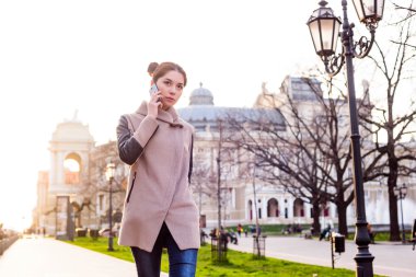 güzel Asyalı kadın sokakta telefon konuşma. Kadında