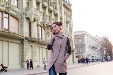 güzel Asyalı kadın sokakta telefon konuşma. Kadında