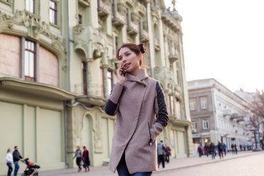 güzel Asyalı kadın sokakta telefon konuşma. Kadında