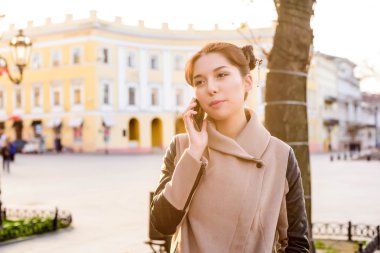 güzel Asyalı kadın sokakta telefon konuşma. Kadında