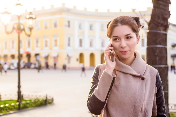 güzel Asyalı kadın sokakta telefon konuşma. Kadında