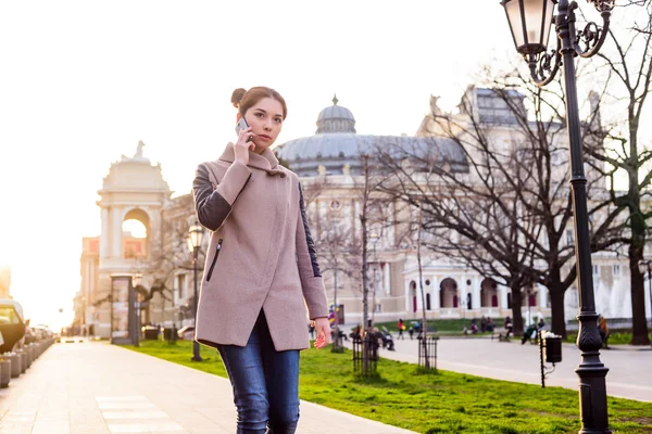 güzel Asyalı kadın sokakta telefon konuşma. Kadında