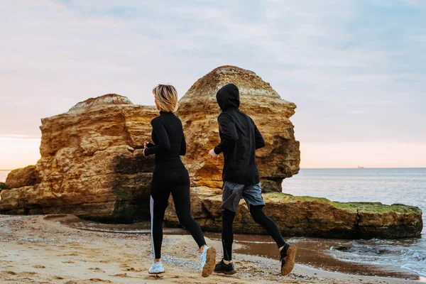 fitness couple running on beach