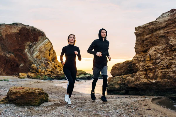 fitness couple running on beach