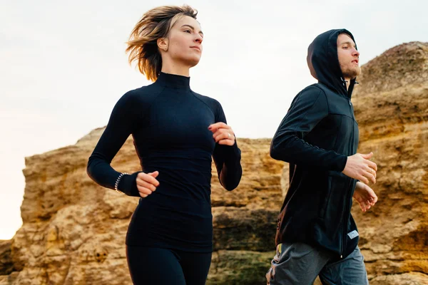 Fitness casal correndo na praia — Fotografia de Stock