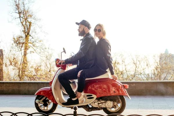 Jeune couple posant sur scooter — Photo