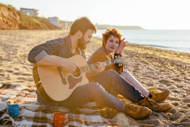 couple playing guitar on beach clipart