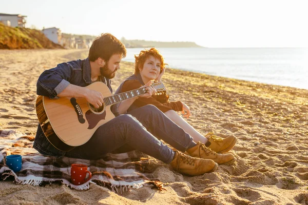 Çift sahilde gitar çalmak